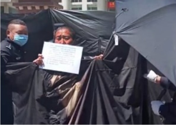 Gonpo Kyi’s peaceful protest for her brother’s fair trial was met with censorship as the authorities attempted to cover her demonstration with long black sheets